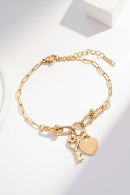 Verstellbares goldenes Kettenarmband mit Herz- und Schlüsselanhängern aus Stahl.